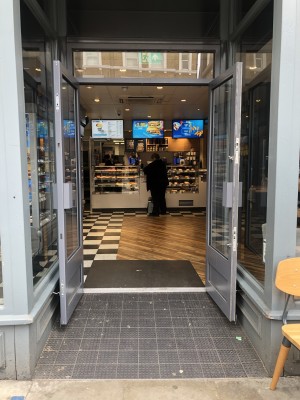 Glass doors with grey frame. Pull handles in centre to open.