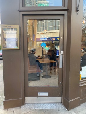 Glass door with brown frame ahead. Push from right to open.