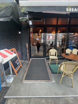 Glass door with black metal frame ahead. Push from handle right to open.