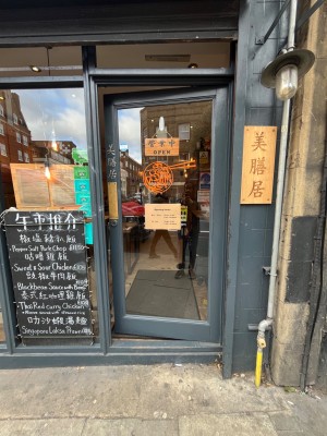 Glass door with grey frames. Push from left to open.