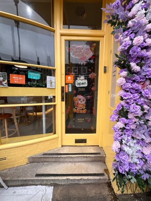 Glass door with yellow frame. Push from metal handle on left to open.