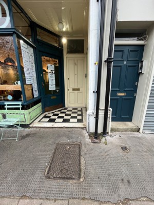 Opening ahead. Outdoor seating to left.