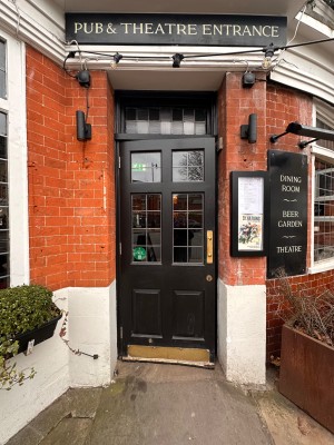 Black wooden door with glass panels. Pull handle from right to open.