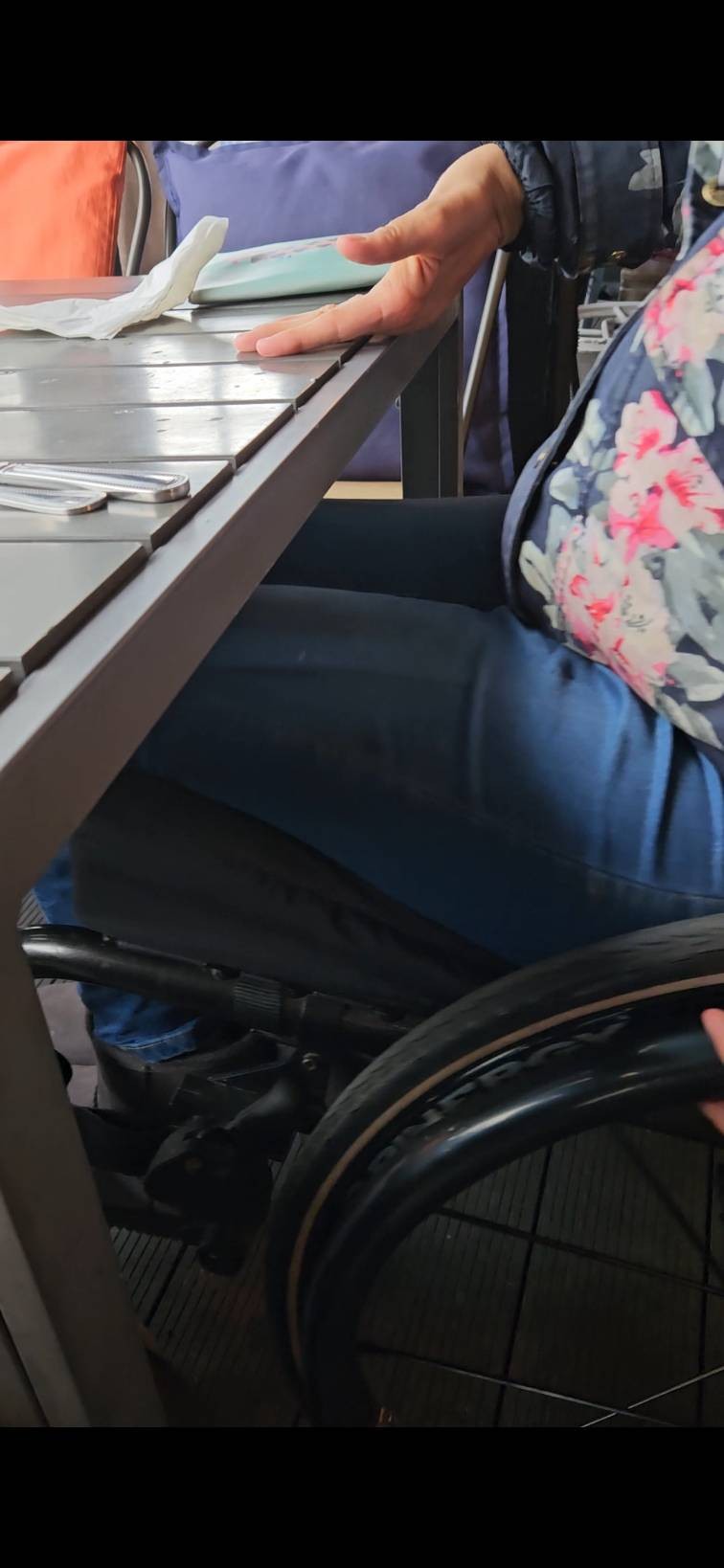 A wheelchair under a table demonstrating the height