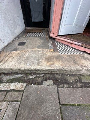 Concrete step up from street to elevated tiled section. Door on right.