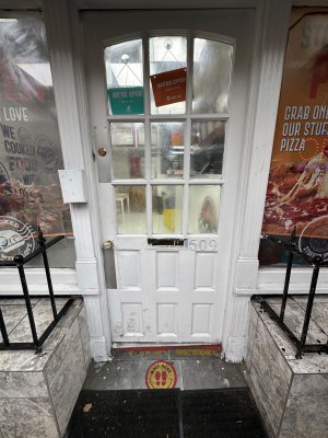 White doorframe and door with glass windows. Push on right to open.