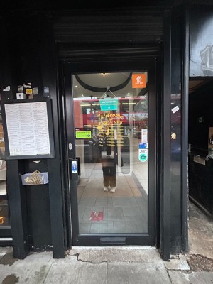Single glass door with black border. Push from handle on left.