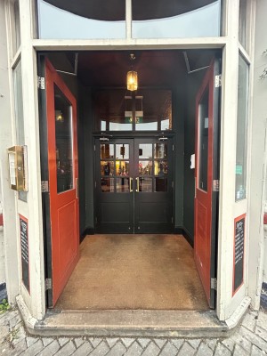 Double wooden orange doors with glass panels. Push from middle to open.