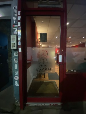 Single glass door with red border. Push handle on right to open.