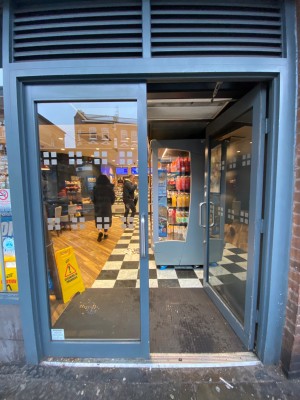 Glass doors with blue frames. Push from metal handles in centre to open.