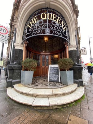 Archway with black marble frame. Two steps up, with planters on left and right at top.