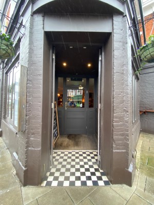 Double brown wooden door. Brass handles. Push from centre to open.
