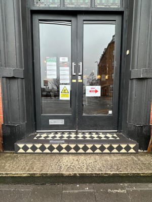 Two steps up to black framed glass doors. Push or pull silver handles in centre to open.