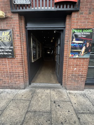 Glass door with a black frame and two metal handles in the middle. Push to open.
