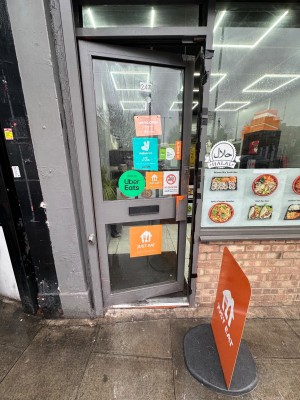 Glass door within grey frame. Push handle on right to open.