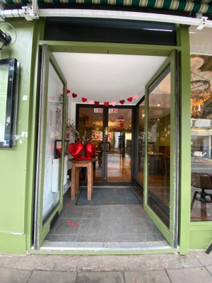 Glass doors with green frames. Push from black handles in centre to open.