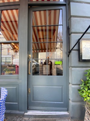 Grey door with glass panel. Push from left to open.