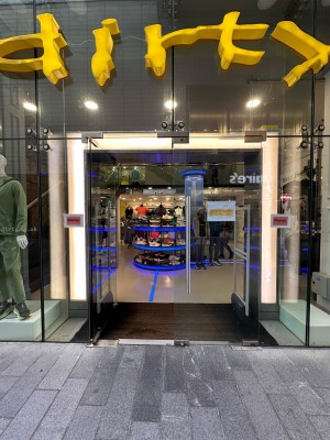 Glass doors with long metal handle. Push from center to open.