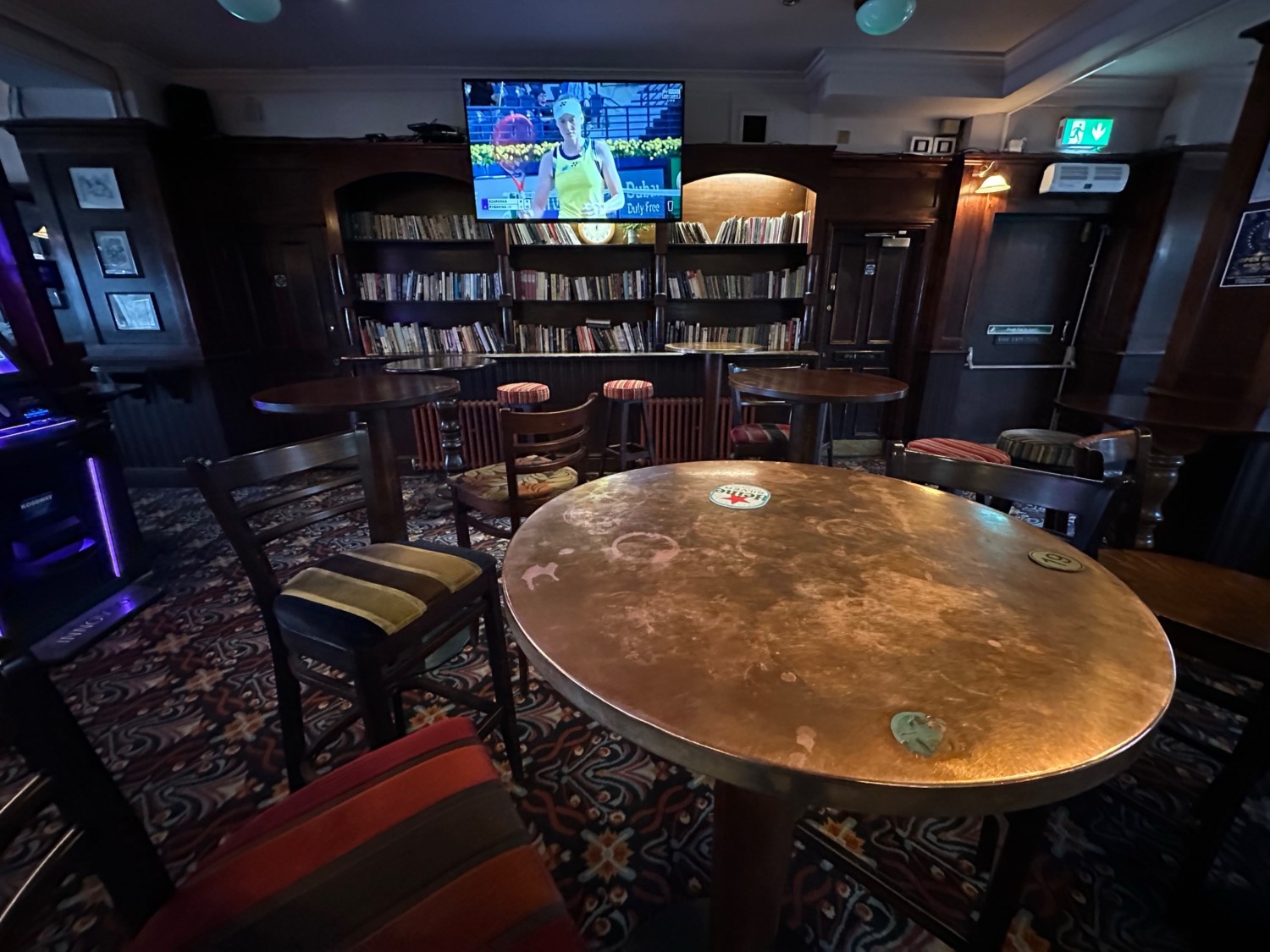 From end of bar facing left. High tables and stools scattered ahead.