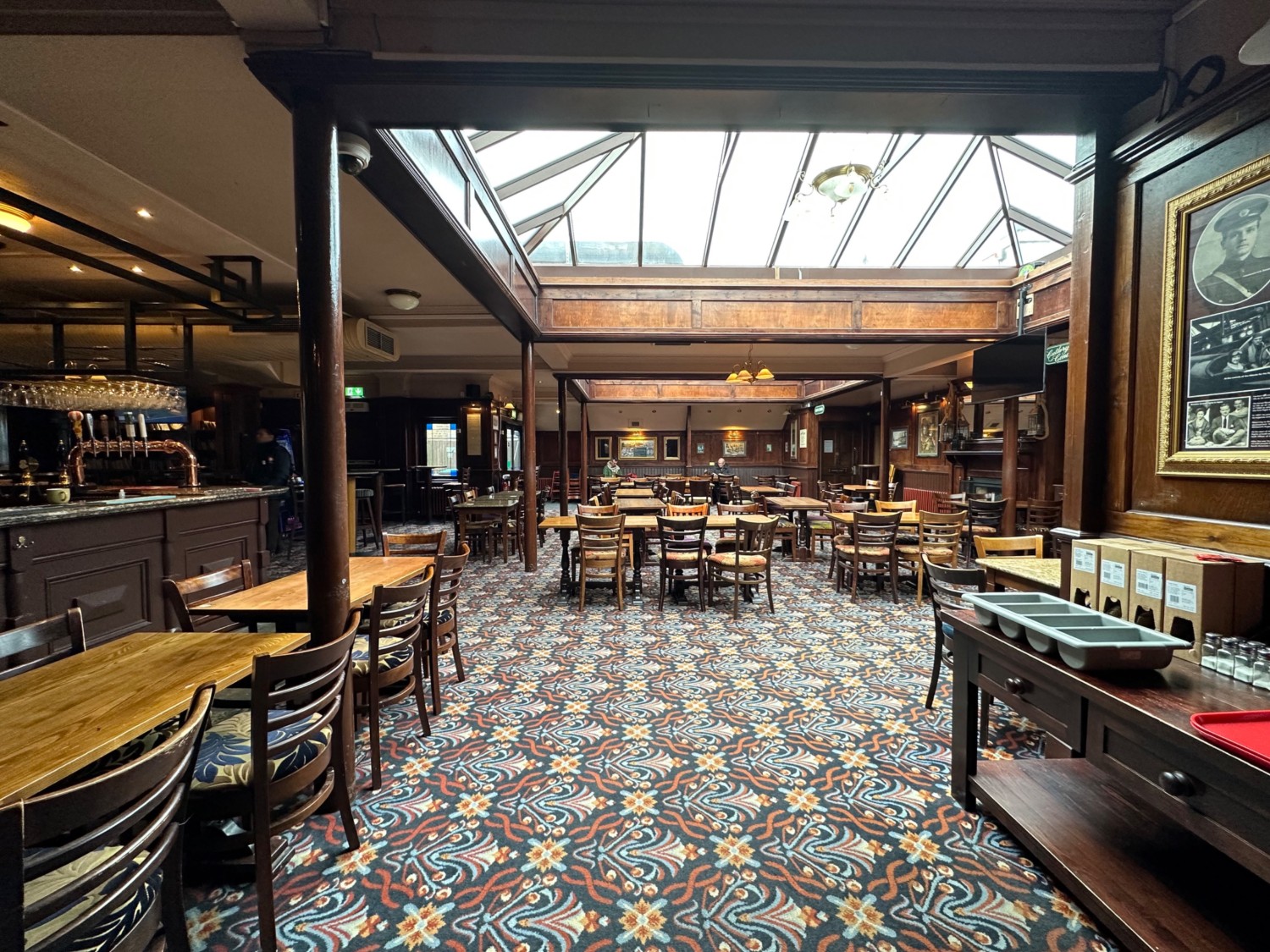 From half booth facing left. Tables and chairs along left and back. Staff counter on right.