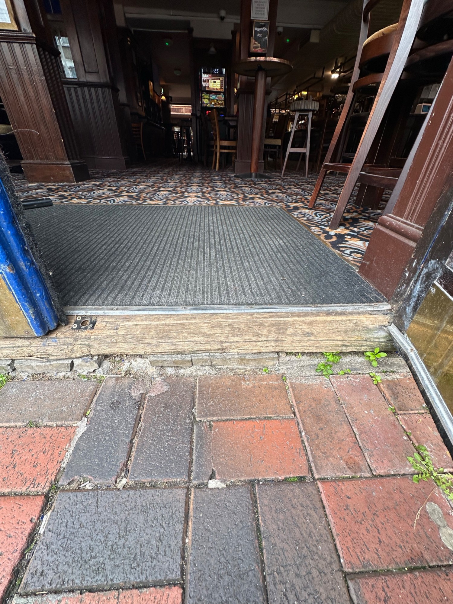 One small step up at foot of door. Doormat behind.