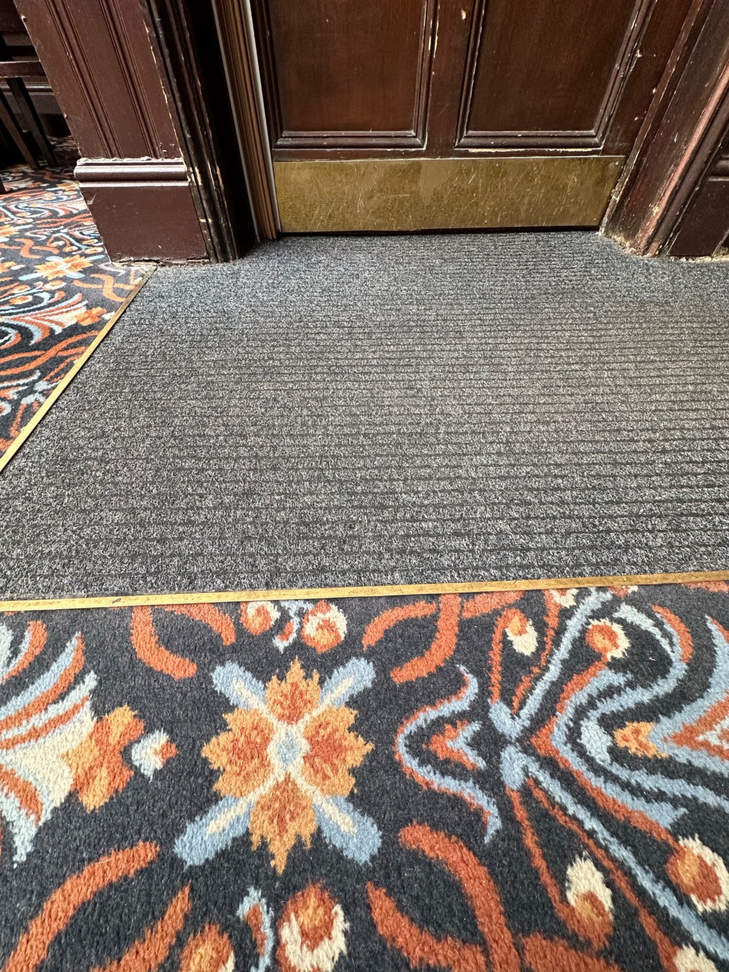 Small bump and doormat before preceding door.