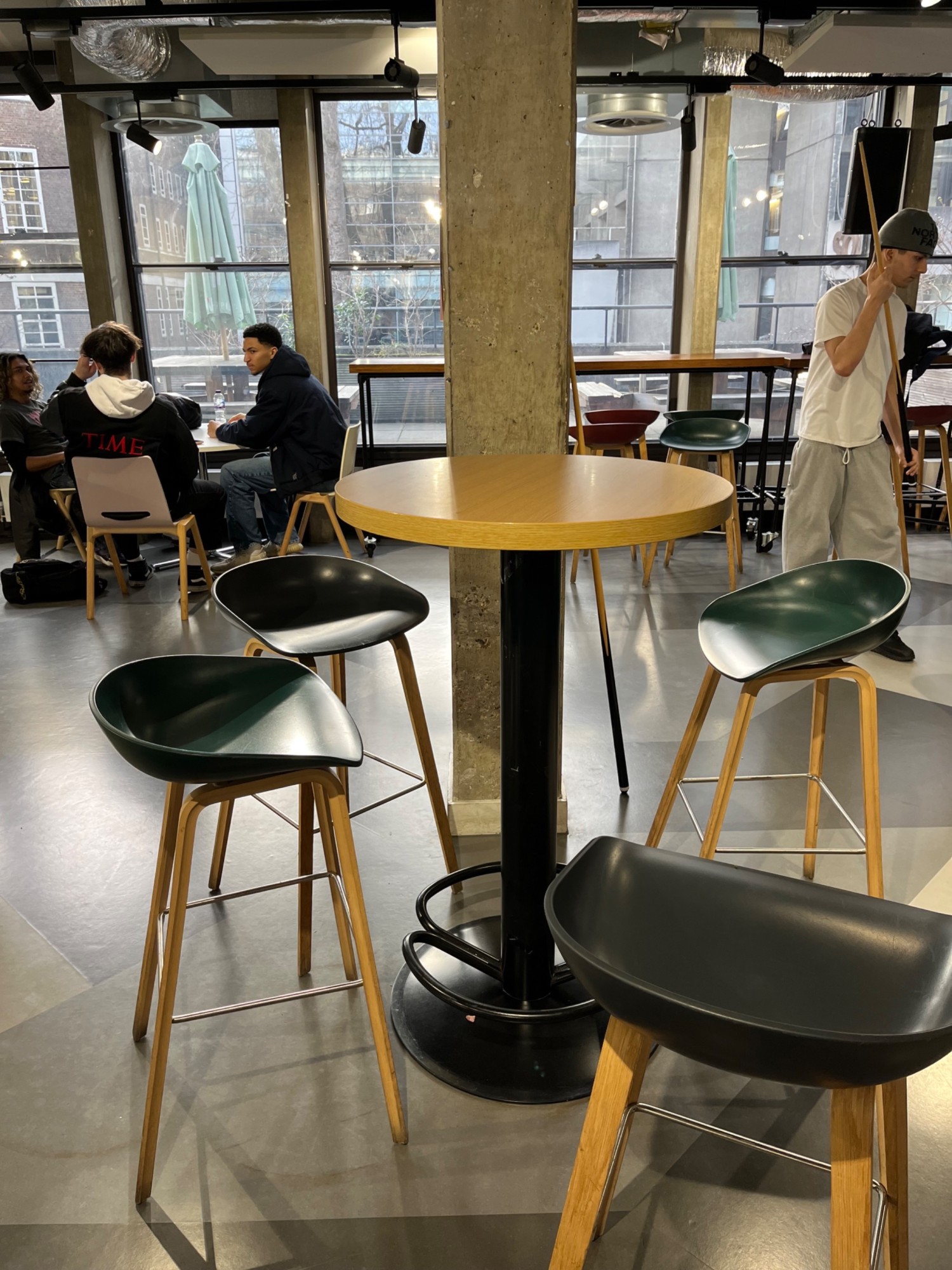 High tables with stools along some pillars. Seating along back wall.