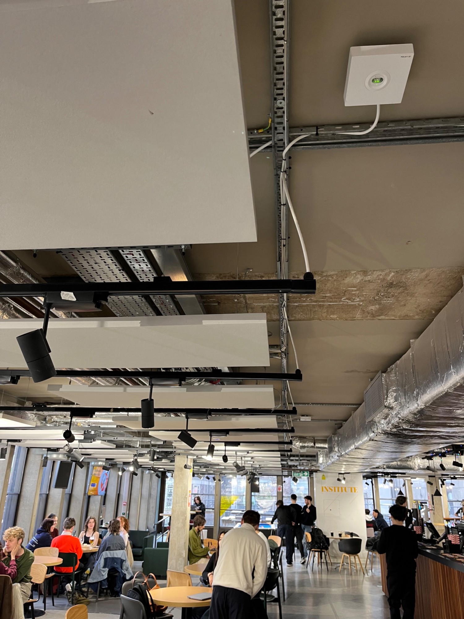The ceiling here is comprised of some panels and is otherwise left un obscured such that pipes and fixtures are visible.