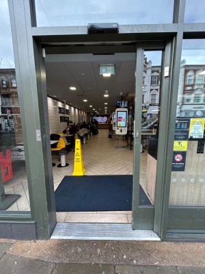 Glass door with grey metal frame ahead, slides from left to right to open.