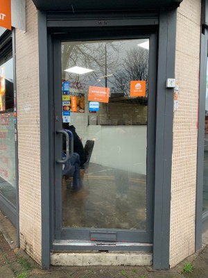 From street looking straight at main entrance. Push from metal handle on left to open.