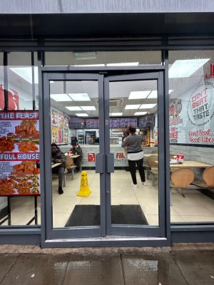 Glass doors with grey frame ahead. Push handles in center to open.