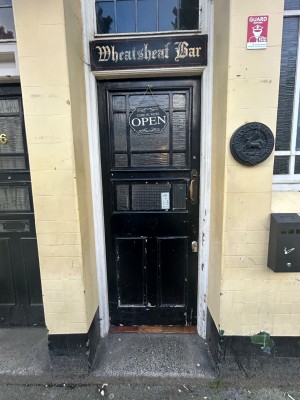Black and glass panelled door. Push gold handle from right to open.