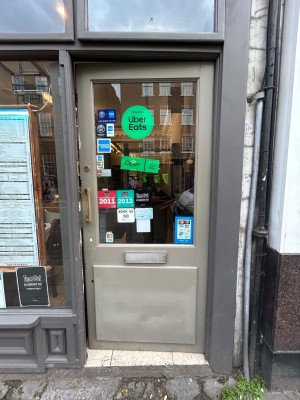 Grey and glass panelled door. Push gold handle from left to open.
