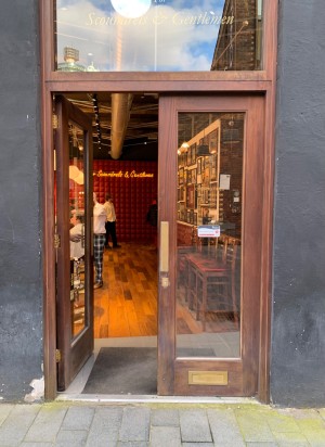 Glass doors with brown, wooden frames ahead. Push from middle to open.