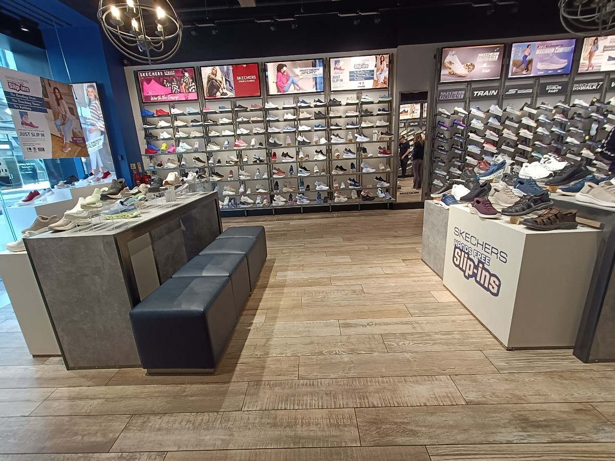 From after first display table, looking left. Display tables on both sides. Stools along left.