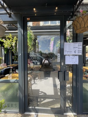 Glass door with grey frame. Pull handle on right to open.