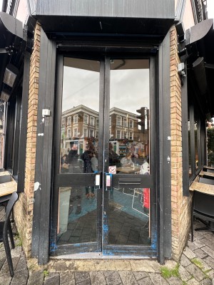 Glass doors with black, wooden frame. Push from middle to open.
