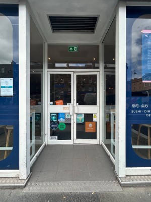 Opening, then double glass doors with white frame. Pull handles in middle to open.