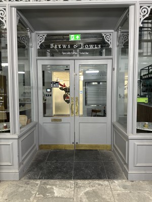 Glass doors with grey frame. Golden handle in the middle. Pull to open.