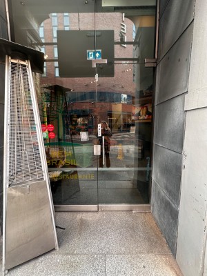 Glass door with silver vertical handle. Pull from left to open.