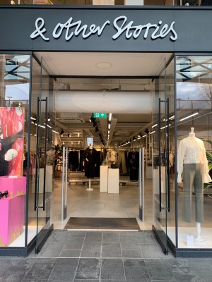 Glass doors. Pull black handles from centre to open.