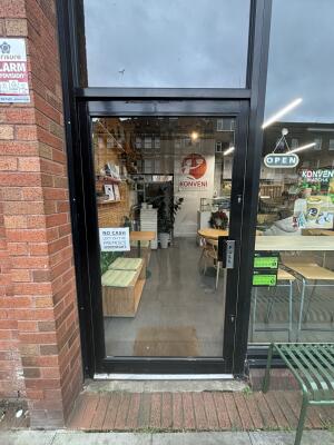 Black framed glass door ahead. Pull handle on right to open.