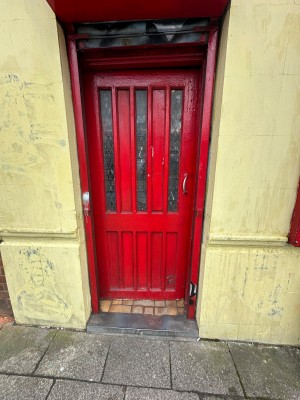 Red framed glared glass door. Push silver handle on right to open.