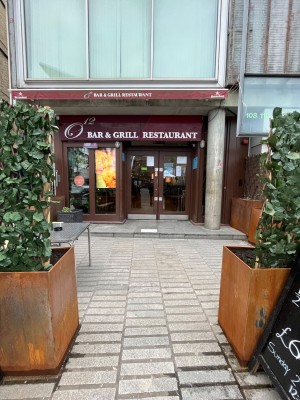 From street facing venue. Opening ahead between planters to main entrance on back.