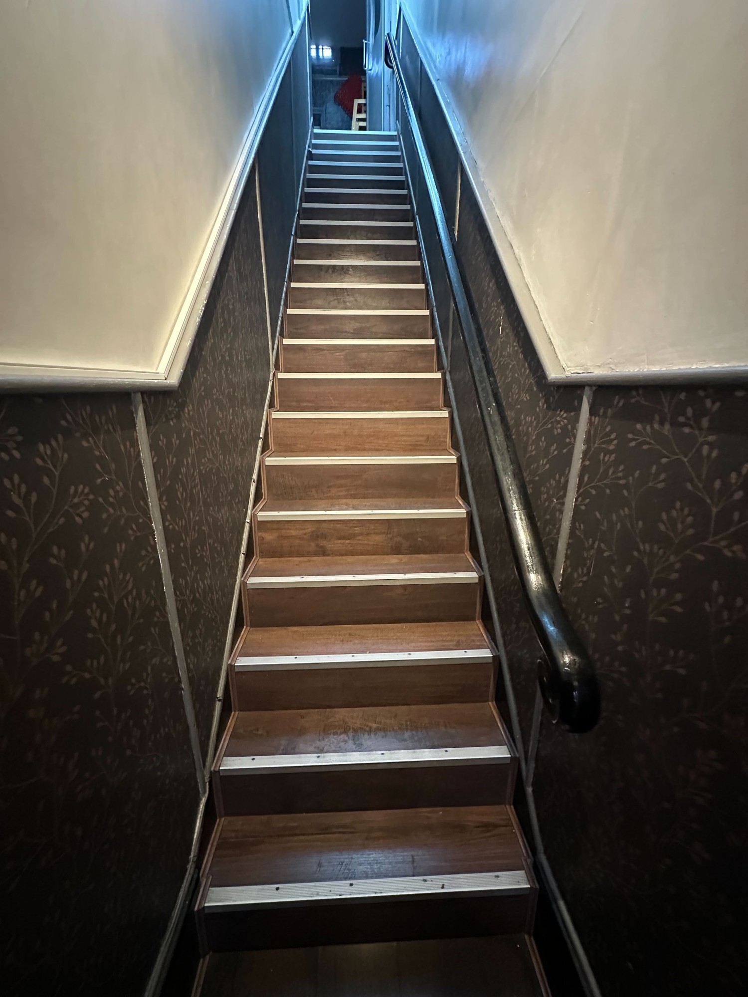 From archway facing straight. Staircase straight up ahead. Handrail to right.