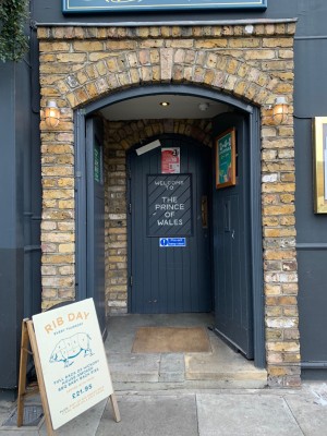 Grey double doors, push from centre to open. Sign on the left before doors.