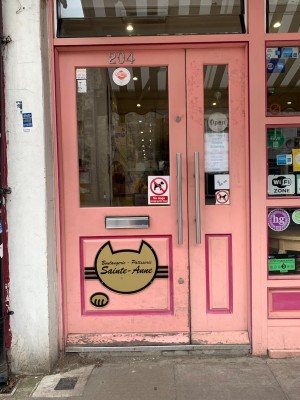 Glass door with pink wooden frames. Push from right to open.