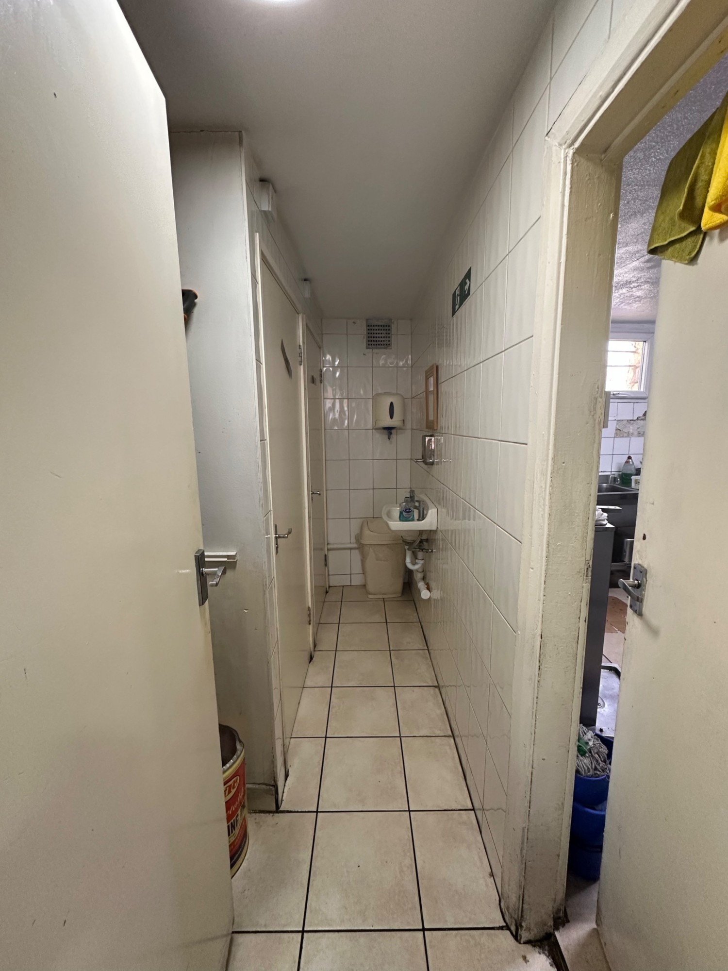 From door facing straight. Men’s bathroom to left. Women’s bathroom behind. Sink to back right.