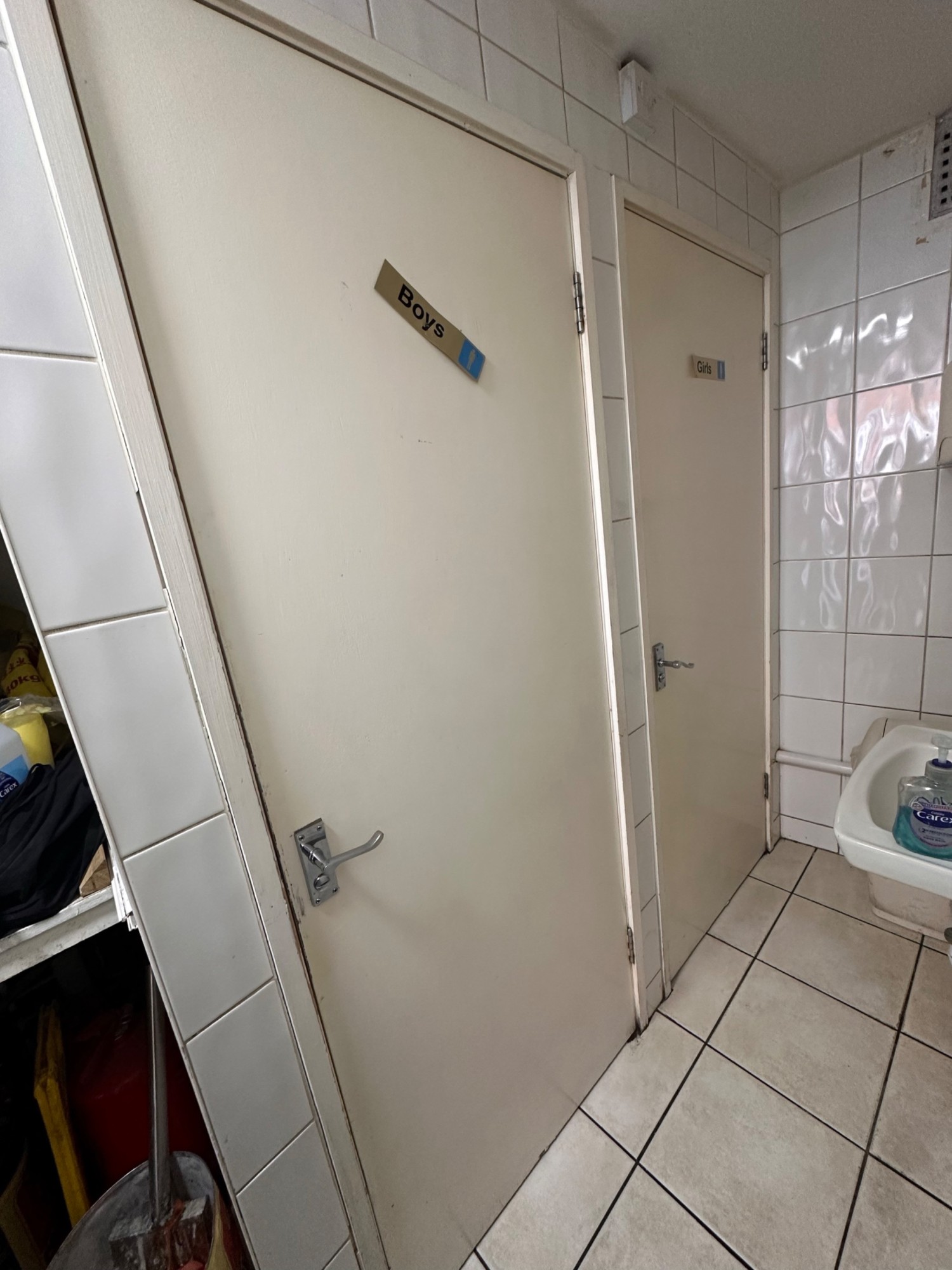 From sink facing left. White bathroom door ahead. Pull silver handle from left to open.