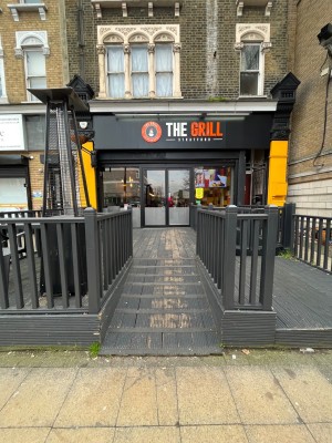 From pavement facing venue. Built in ramp leading to path, which leads to front doors of venue.
